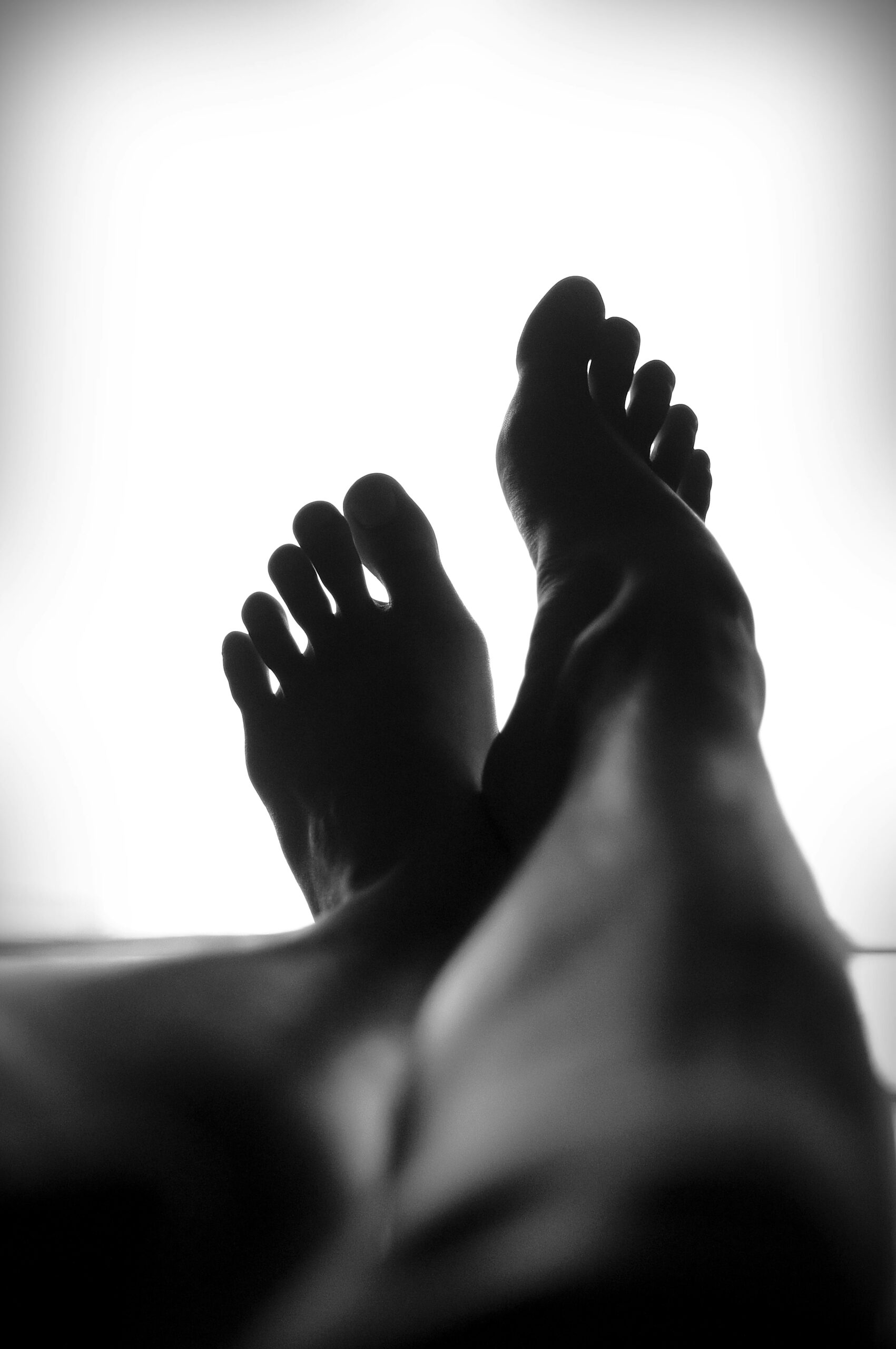 Person's bare feet elevated showing bottom of feet, representing plantar fasciitis heel pain relief in Northbrook